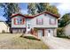 Charming two-story home with gray siding, red trim, shutters, covered front entrance, and driveway at 1284 To Lani Path, Stone Mountain, GA 30083