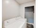 Bright laundry room featuring a white washer and dryer set next to a doorway with checkered tile flooring at 1284 To Lani Path, Stone Mountain, GA 30083