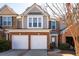 Charming two-story townhouse with a brick facade, double garage, and well-manicured landscaping at 195 Finchley Dr, Roswell, GA 30076