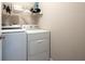 Laundry area featuring white front-load washer and dryer with wire shelving above at 195 Finchley Dr, Roswell, GA 30076