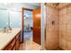 Neutral bathroom features a stone tiled shower and vanity; bedroom visible in the background at 2191 Spear Point Dr, Marietta, GA 30062