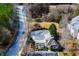 Aerial view of a neighborhood pool, playground and clubhouse with mature trees, common area, and parking at 2326 Bigwood Trl, Atlanta, GA 30349