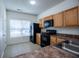 Kitchen featuring stainless steel sink, tile floors, a window and black appliances at 2326 Bigwood Trl, Atlanta, GA 30349