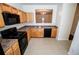 Kitchen view with sleek black appliances, wooden cabinets, and modern tile flooring at 2326 Bigwood Trl, Atlanta, GA 30349