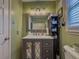 Cozy bathroom featuring a vanity with storage and decorative mirror at 2056 Merle Se Dr, Conyers, GA 30013