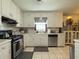 Kitchen featuring stainless steel appliances, white cabinets, tile floors, and natural light at 2056 Merle Se Dr, Conyers, GA 30013