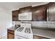 Close-up of kitchen area showing a white range, microwave, dark cabinets and tiled backsplash at 4422 Wellington Ter, Decatur, GA 30035