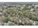 Drone eye view of a residential area with lush trees, homes, and roads in a beautiful natural surrounding at 447 Hemlock Dr, Pine Lake, GA 30083