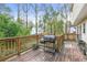 Wooden deck with a grill surrounded by lush green trees at 447 Hemlock Dr, Pine Lake, GA 30083