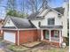 Charming home showcasing a brick facade, inviting front porch, and an attached garage with natural landscaping at 447 Hemlock Dr, Pine Lake, GA 30083