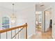 Second floor hallway illuminated by beaded chandelier with view to office at 447 Hemlock Dr, Pine Lake, GA 30083