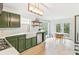 Spacious kitchen featuring white countertops, green cabinetry, stainless appliances and breakfast table at 447 Hemlock Dr, Pine Lake, GA 30083