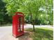 Unique red English phone booth adds character to the property's surroundings at 447 Hemlock Dr, Pine Lake, GA 30083