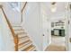 A bright staircase with a wood railing and a view into an adjacent kitchen at 447 Hemlock Dr, Pine Lake, GA 30083