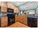 Well-lit kitchen features wooden cabinets, granite countertops and black appliances at 1945 Bay Beauty Ln # 10, Austell, GA 30106