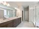 Luxury bathroom featuring double sinks, gray cabinets, and a large, modern mirror at 2460 Hidden Creek Rd, Kennesaw, GA 30152