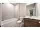 Well-lit bathroom features a shower-tub combination with white tile and a vanity with a dark wood cabinet at 2460 Hidden Creek Rd, Kennesaw, GA 30152