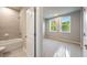 Inviting bathroom with a shower over tub and a connected bedroom with bright light at 2460 Hidden Creek Rd, Kennesaw, GA 30152