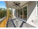 Covered deck overlooking a wooded area, featuring grey stained wood, a ceiling fan, and sliding glass doors at 2460 Hidden Creek Rd, Kennesaw, GA 30152