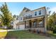 Attractive two-story house showcasing gray siding, brick details, a cozy front porch, and a neatly maintained lawn at 2460 Hidden Creek Rd, Kennesaw, GA 30152