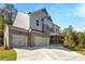 Elegant home with a three-car garage, a mix of gray siding and brick, and a charming front porch at 2460 Hidden Creek Rd, Kennesaw, GA 30152