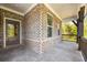 Inviting covered porch with brick base, dark wood trim, and a view of the outdoors at 2460 Hidden Creek Rd, Kennesaw, GA 30152