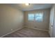 Cozy bedroom with neutral walls, plush carpeting, and natural light from a large window at 3924 Veracruz Dr, Decatur, GA 30034