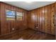 Bedroom featuring wood paneling, wood floors, and a window bringing in natural light at 765 Shellnut Dr, Forest Park, GA 30297