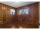 Bedroom featuring wood paneling, wood floors, and two windows bringing in natural light at 765 Shellnut Dr, Forest Park, GA 30297