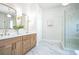 Bright bathroom features double sinks, wood cabinets, modern fixtures, and glass enclosed shower with decorative tile at 1826 Terry Mill Se Rd, Atlanta, GA 30316