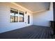 Comfortable covered back porch with stained wood flooring and neutral color siding at 1480 Baygreen Rd, Suwanee, GA 30024