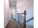 Hallway featuring neutral walls, brown carpet and a wooden and iron railing at 1480 Baygreen Rd, Suwanee, GA 30024