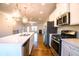 Open-concept kitchen with stainless steel appliances, center island, and hardwood floors, leading to living area at 1480 Baygreen Rd, Suwanee, GA 30024