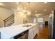 Spacious kitchen with stainless steel appliances, white cabinets, and open view of the living room fireplace at 1480 Baygreen Rd, Suwanee, GA 30024