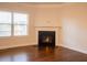 Cozy living room featuring a traditional fireplace with white mantle and hardwood flooring at 1480 Baygreen Rd, Suwanee, GA 30024