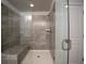 Contemporary shower area with glass doors, a built-in bench, and stylish tile at 1480 Baygreen Rd, Suwanee, GA 30024