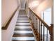Elegant staircase with hardwood treads, white risers, and decorative wrought iron balusters for a modern look at 1480 Baygreen Rd, Suwanee, GA 30024