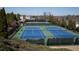 This photo displays the well-maintained community tennis courts, bordered by greenery and fencing at 1480 Baygreen Rd, Suwanee, GA 30024