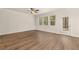 Bright living room with hardwood floors, large windows, and a ceiling fan, creating a comfortable living space at 1094 Georgian Point Rd, Lawrenceville, GA 30045