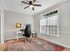 Functional office space featuring a large window, ceiling fan, desk setup, and an attractive area rug at 146 River Ridge Ln, Roswell, GA 30075