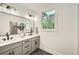 Bright bathroom featuring dual sinks, modern fixtures, and a large window, creating a serene and functional space at 1523 Grayson Pkwy, Grayson, GA 30017