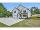 Spacious driveway leading to a white brick home with a well-manicured lawn and mature trees at 1523 Grayson Pkwy, Grayson, GA 30017