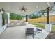 Covered outdoor kitchen with stone surround, ceiling fan, and space for dining and relaxation at 1523 Grayson Pkwy, Grayson, GA 30017