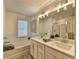 Modern bathroom featuring double vanity, glass shower, and soaking tub with tile backsplash at 172 Ne Almand Ln, Conyers, GA 30013