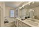 Modern bathroom featuring double vanity, glass shower, and soaking tub with tile backsplash at 172 Ne Almand Ln, Conyers, GA 30013