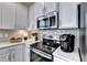 A close up of the kitchen with stainless steel appliances, white cabinets, and sleek countertops at 172 Ne Almand Ln, Conyers, GA 30013