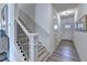 Bright foyer with staircase featuring modern wood steps and dark metal railing at 172 Ne Almand Ln, Conyers, GA 30013