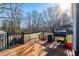 A spacious deck with a black metal railing overlooks a fenced in backyard, with wooded views, and a large grill at 2421 Pittman Cir, Cumming, GA 30040