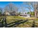 View of a house with a big backyard surrounded by a black wooden fence and lots of trees at 2421 Pittman Cir, Cumming, GA 30040