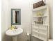 Small bathroom with pedestal sink, decorative mirror and white corner shelving at 2421 Pittman Cir, Cumming, GA 30040